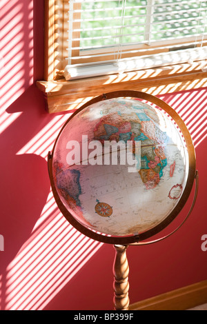 Vintage des années 1980 World Globe sur le stand en face de la fenêtre Banque D'Images