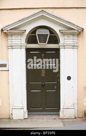 Porte avant peint en vert no. Avec 9 bouton laiton heurtoir letterbox fronton triangulaire et architrave de maison de ville géorgienne en UK Banque D'Images