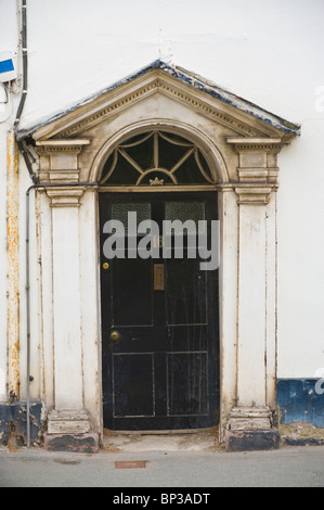 Scruffy lambrissés noir n° de porte avant 16 Blanc avec fronton triangulaire et architrave de maison de ville géorgienne en UK Banque D'Images