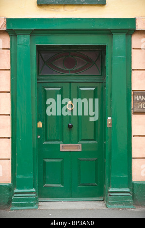 Panneaux en bois peint vert porte avant avec heurtoir laiton bouton noir letterbox et imposte de Georgian House en UK Banque D'Images