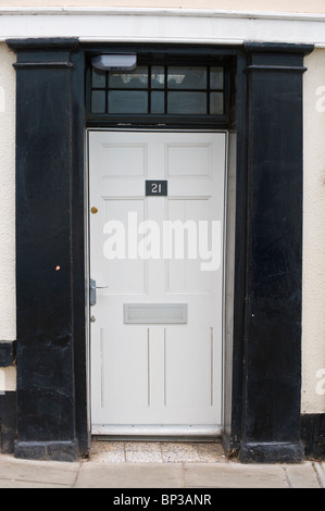 Moderne peint en blanc avant lambrissés porte no 21 avec poignée noire de boîte aux lettres et de surround période maison de ville à UK Banque D'Images