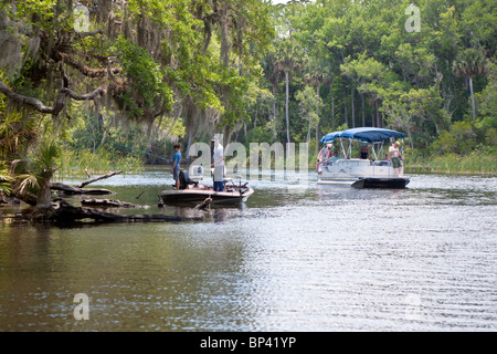 Famille dans un bateau ponton passe une jeune fille avec son grand-père de pêche sur la rivière Salt en Floride centrale Banque D'Images