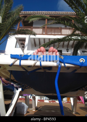 Les filles les orteils à l'extrémité de transat tandis que les bains de soleil Banque D'Images