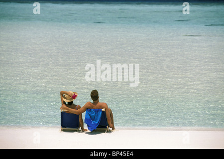 L'Asie, les Maldives, l'Atoll Felidu. Couple de détente sur les chaises de plage Banque D'Images