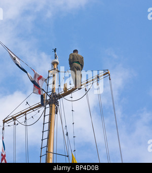 Crewman monter sur la plus haute cour de l'arrière du mât d'un voilier trois-mâts barque-goélette (Le Dewaruci) Banque D'Images