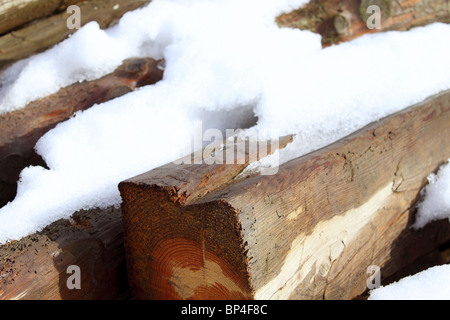 Neige sur des poutres en bois humide d'hiver Banque D'Images