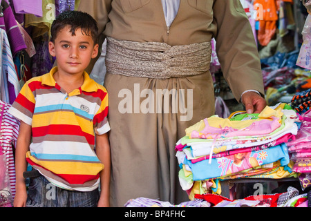 Garçon kurdes iraquiens chez son père dans la boutique le bazar, de Dohouk, Kurdistan, Iraq Banque D'Images