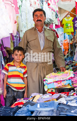 Garçon kurdes iraquiens chez son père dans la boutique le bazar, de Dohouk, Kurdistan, Iraq Banque D'Images