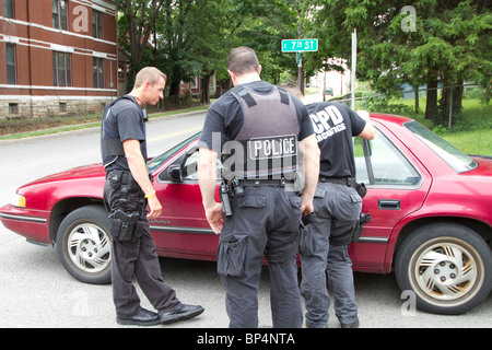 Des agents de police de l'équipe tactique de parler à un individu trouvé dormir dans un véhicule dans une intersection. Kansas City, MO, PD. Banque D'Images