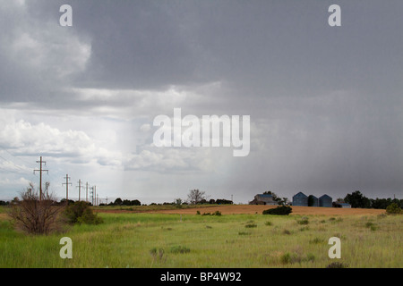 La pluie tombait sur farmhouse et silos dans un orage dans les régions rurales et agricoles de sud-ouest du Colorado Banque D'Images