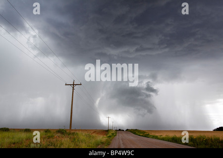 Cumulus qui se profile en colère orage pluie nuages relâchant dans un orage, avec chemin de terre menant à la distance Banque D'Images