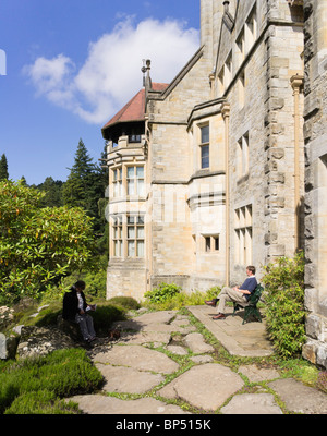 Cragside historic house Northumberland Royaume-uni - deux personnes se détendre et lire à l'extérieur de la chambre Banque D'Images