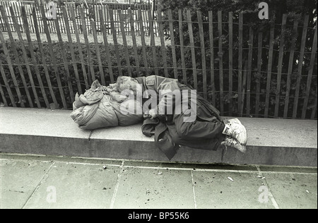 Un homme sans-abri dort le long de la 5e Avenue, juste en dehors de Central Park à New York. Banque D'Images