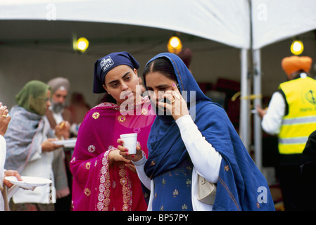 Les sikhs Woman talking on Cell phone / téléphone mobile aide pour l'appel sur le Vaisakhi Parade, Surrey, BC, British Columbia, Canada Banque D'Images