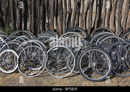 Les roues de bicyclette empilés le long de clôture en bois à l'arrière d'un atelier de réparation de vélos à Corrales, New Mexico, le 10 juin, 2010 Banque D'Images