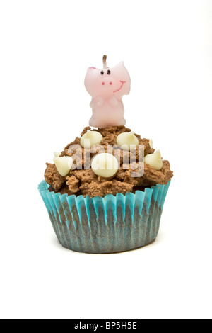 Le chocolat au lait fait maison birthday cupcake au chocolat blanc décoration chute et bougie. Banque D'Images