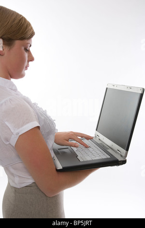 De récolte Woman holding laptop et dactylographie Banque D'Images