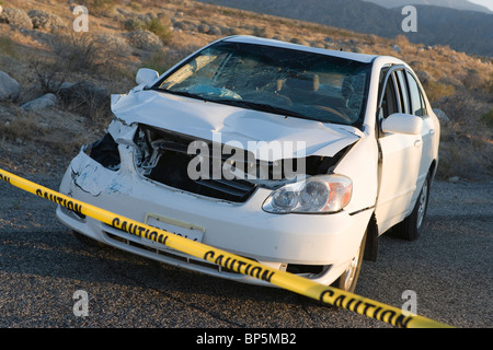 Voiture fracassé bouclés derrière bande de police Banque D'Images