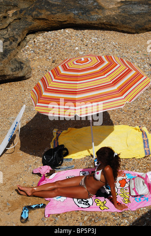 Jolie femme sous un parasol sur la plage, Cadix, Costa de la Luz, Province de Cadiz, Andalousie, Espagne, Europe de l'Ouest. Banque D'Images
