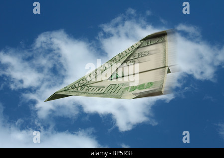 Un avion en papier fait à partir d'un billet de cent dollars US le vol avec la motion sur un fond de ciel bleu et nuages blancs Banque D'Images