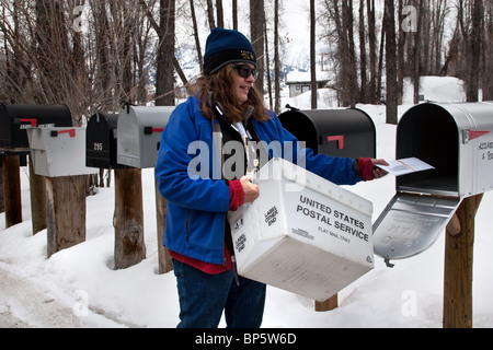 Publiez Dame de distribuer les lettres dans les boîtes aux lettres en France Banque D'Images