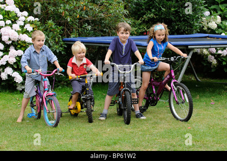 Quatre enfants jouant sur leur bicyclette Banque D'Images