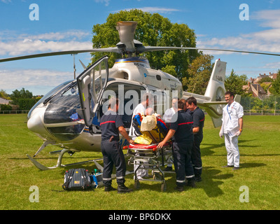 L'équipe de sauvetage transportant un patient à l'Eurocopter EC135 air ambulance - Indre-et-Loire, France. Banque D'Images