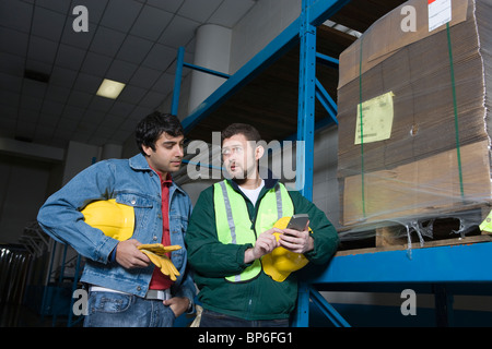 Les hommes à l'aide de la calculatrice dans factory Banque D'Images
