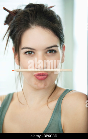 Woman balancing un crayon à lèvres sur Banque D'Images