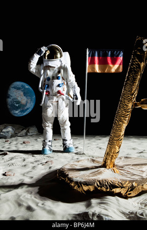 Un astronaute près d'un Lunar Lander salue un drapeau allemand Banque D'Images