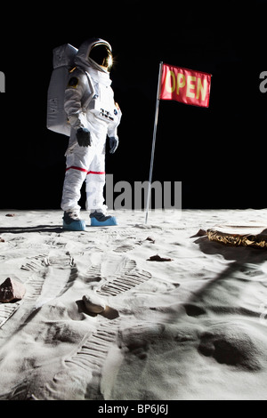 Un astronaute sur la lune à côté d'un drapeau d'ouvrir sur elle Banque D'Images