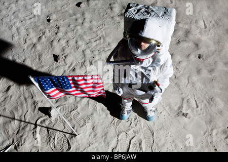 Un astronaute sur la surface de la lune à côté d'un drapeau américain Banque D'Images