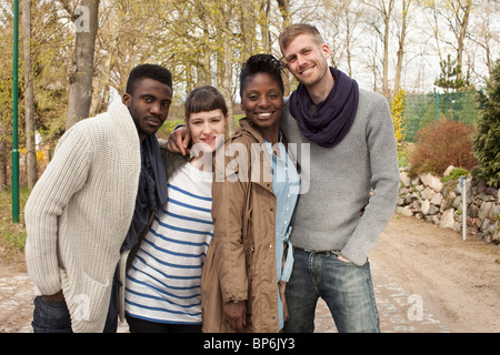 Quatre amis avec leurs bras autour de l'autre Banque D'Images