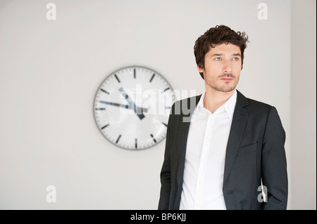 Businessman standing in front of a clock Banque D'Images
