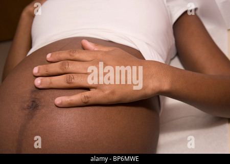 Une femme enceinte allongée sur une table d'examen, side view Banque D'Images