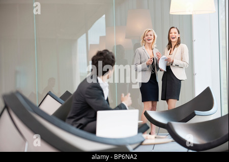 Businessman dans une salle d'attente à la recherche de ses collègues en souriant à l'arrière-plan Banque D'Images