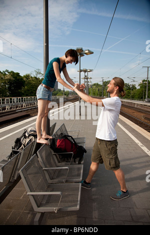 Un jeune couple s'amusant en attendant sur une plate-forme du train Banque D'Images