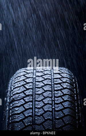 Détail de pluie qui tombe sur un pneu de voiture Banque D'Images