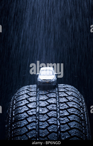 Détail de pluie qui tombe sur une petite voiture sur un pneu Banque D'Images