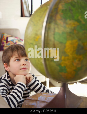 Un garçon regarde un world globe Banque D'Images