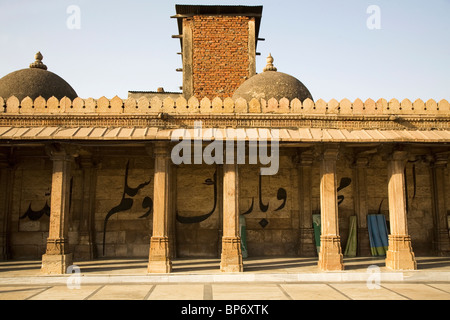 Une inscription coranique court derrière des piliers dans le Jama Masjid (mosquée du vendredi) à Ahmedabad, Gujarat, Inde. Banque D'Images