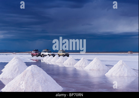 Les voitures sur le Salar de Uyuni au coucher du soleil, Potosi, Bolivie Banque D'Images