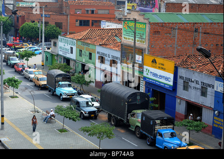 Et la circulation des véhicules en stationnement sur la route à l'extérieur des magasins dans Medellin, Amérique du Sud Banque D'Images