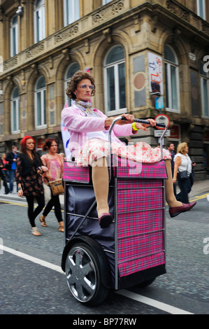 Les hommes habillés comme des vieilles dames à cheval sur l'utilisation d'un Segway fait comme des paniers à Liverpool à l'événement gay pride - Août 2010 Banque D'Images