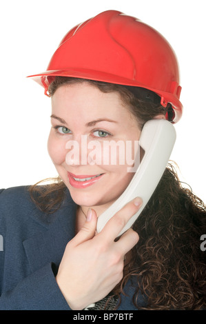 Belle jeune femme en rouge hard hat appelant par téléphone. Isolé sur fond blanc Banque D'Images