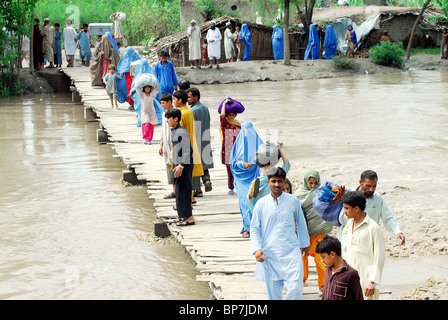 Les victimes les gens passent leurs biens vers l'endroit sûr après inondation à Charsadda road à Peshawar Banque D'Images