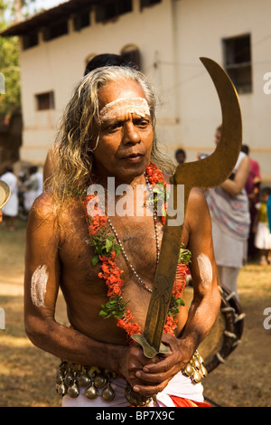 Un homme porte un sabre de cérémonie lors d'une procession à Olappamanna Mana dans le Kerala, en Inde. Il est considéré comme l'Kali. Banque D'Images