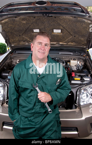 Un mécanicien d'automobile est titulaire d'une clé avant d'effectuer la réparation et l'entretien du moteur sur une voiture. Banque D'Images