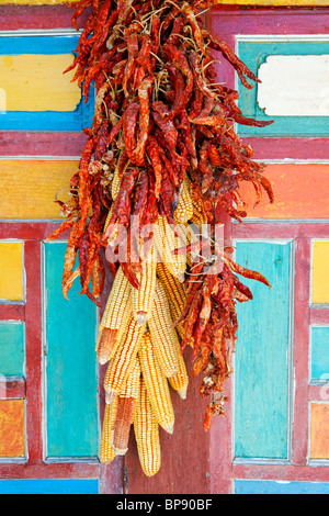 Un tas de piment rouge et le maïs accroché sur un mur. La province du Sichuan, Chine Banque D'Images