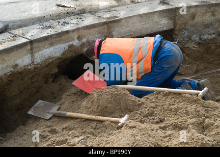 Travailleur de la construction de l'ensemble de creuser dans la construction routière Banque D'Images